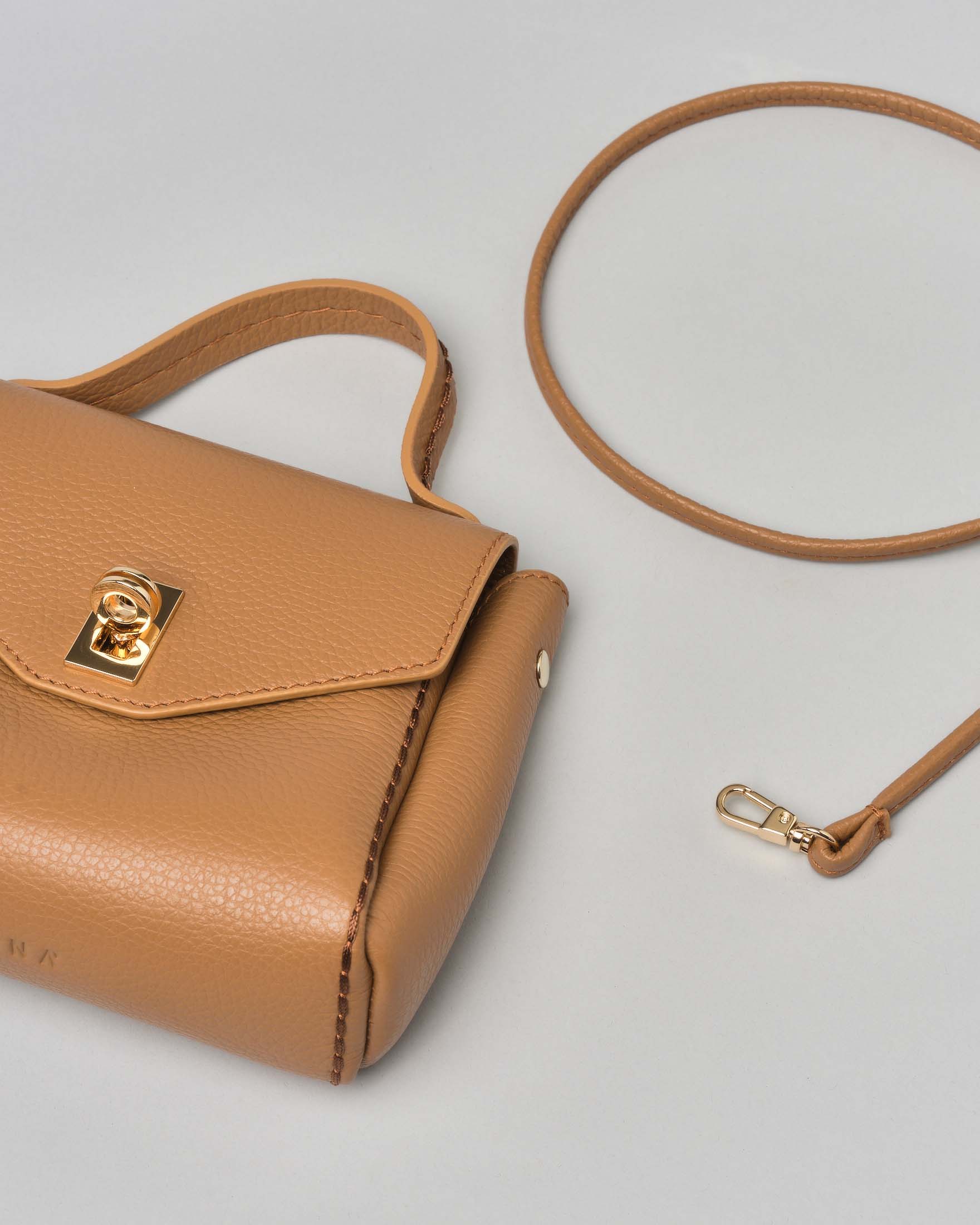 Mini bag a mano in pelle color cammello con impunture e patta di chiusura image