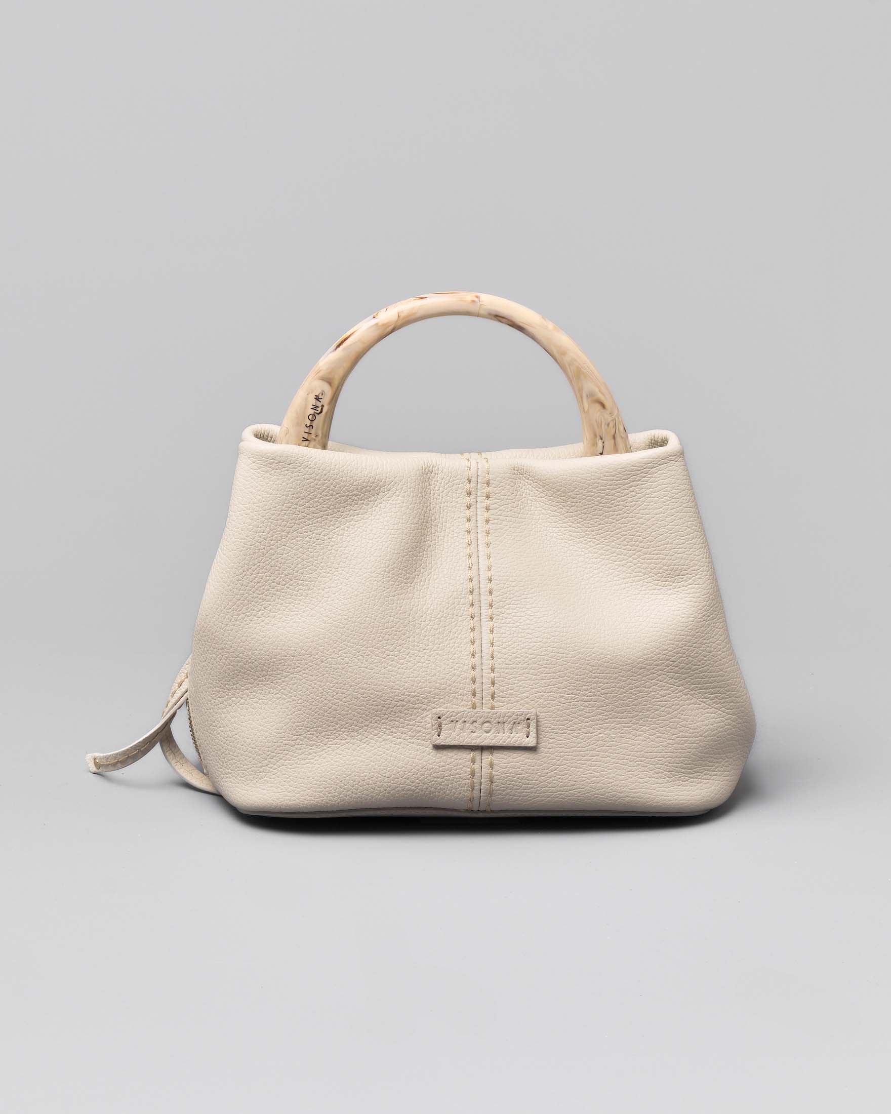 Borsa color latte in pelle martellata misura piccola con manico in osso tono su tono e impunture a vista