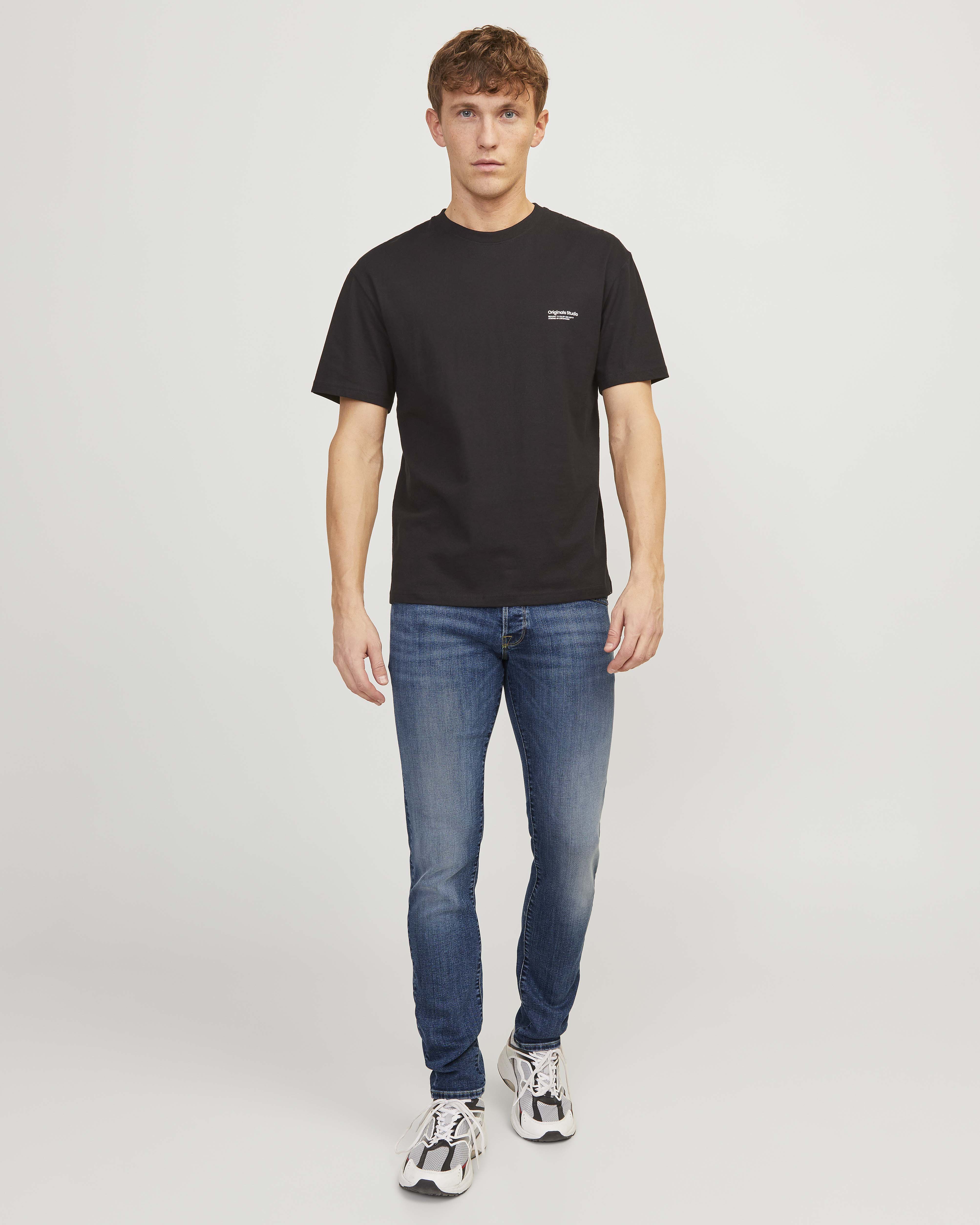 Jeans slim a vita bassa in cotone stretch lavaggio medio stone washed con leggere sabbiature e baffature