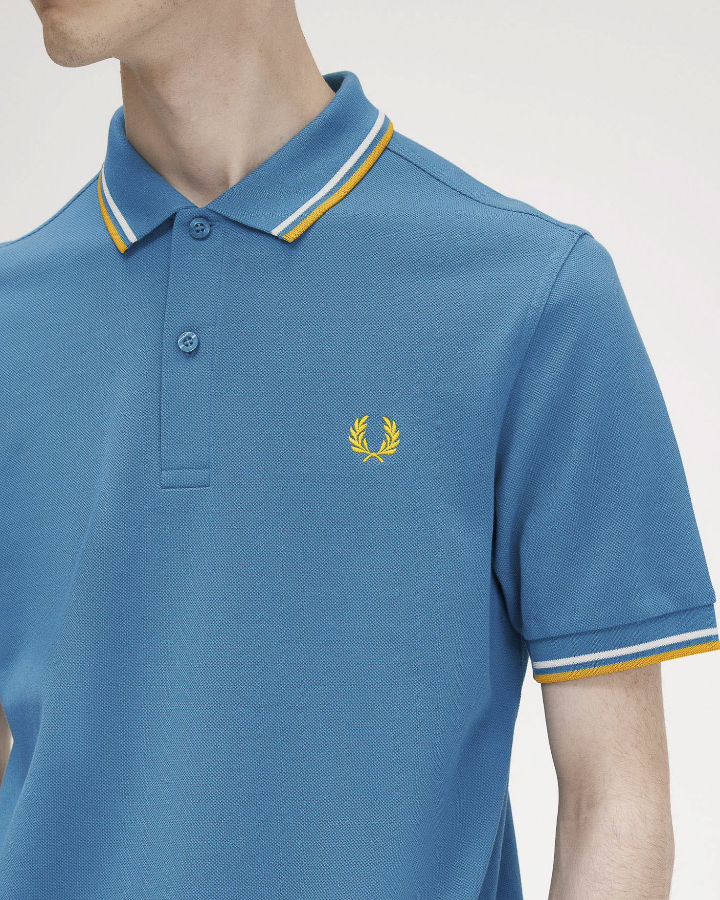 Polo turchese mezza manica con bordino bianco e giallo image