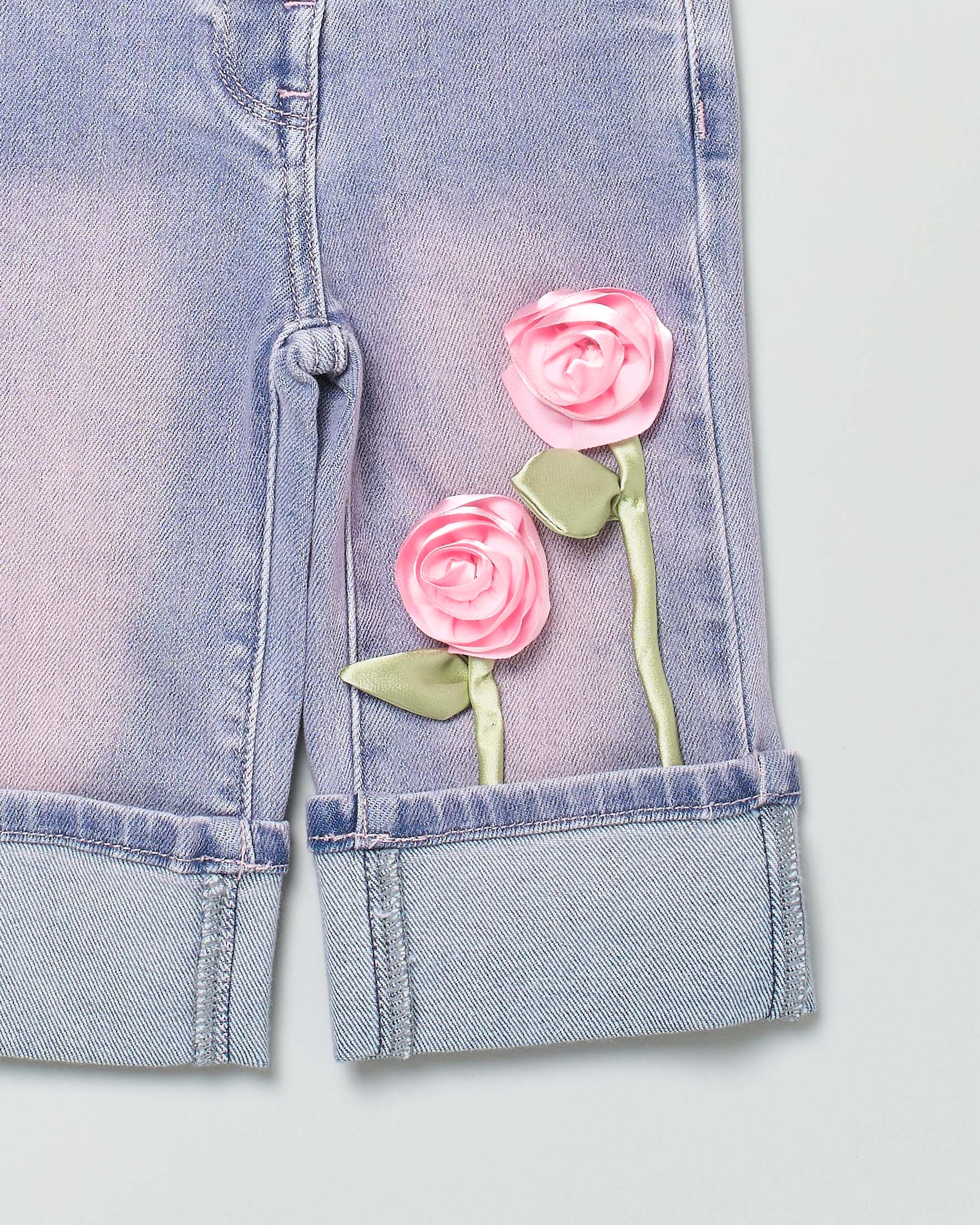 Jeans Monnalisa lavaggio chiaro stone washed con maxi risvolto e rose applicate image