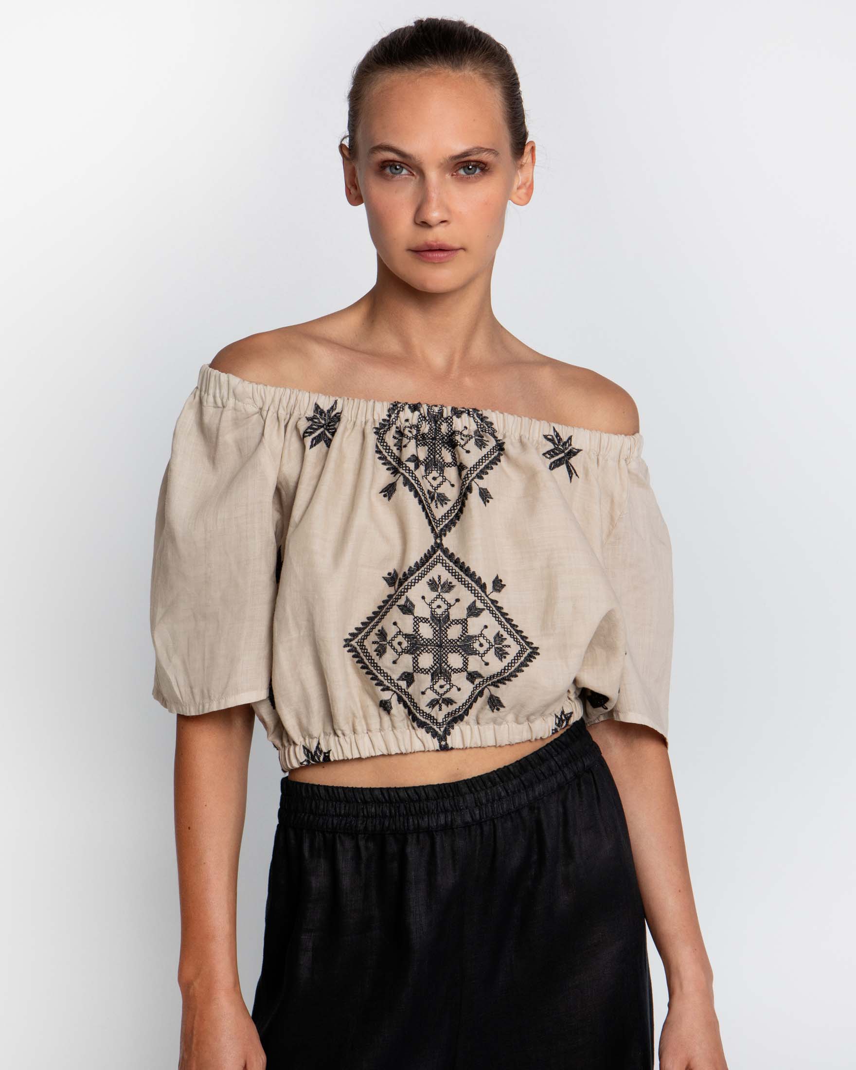 Top off shoulder beige in ramiè con ricami neri ed elastico inserito lungo i profili