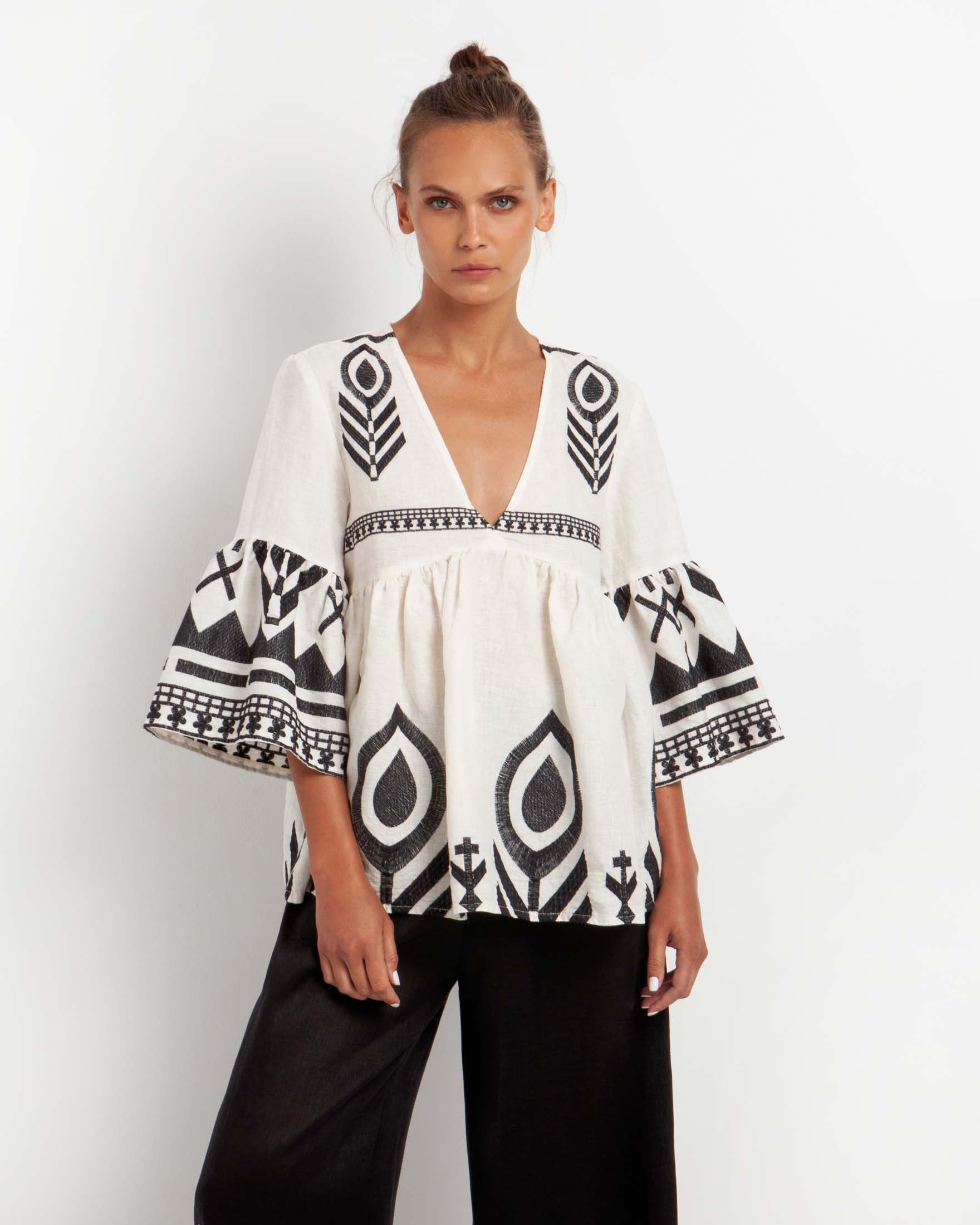 Blusa bianca in lino con ricami neri, scollo a V e maniche a campana