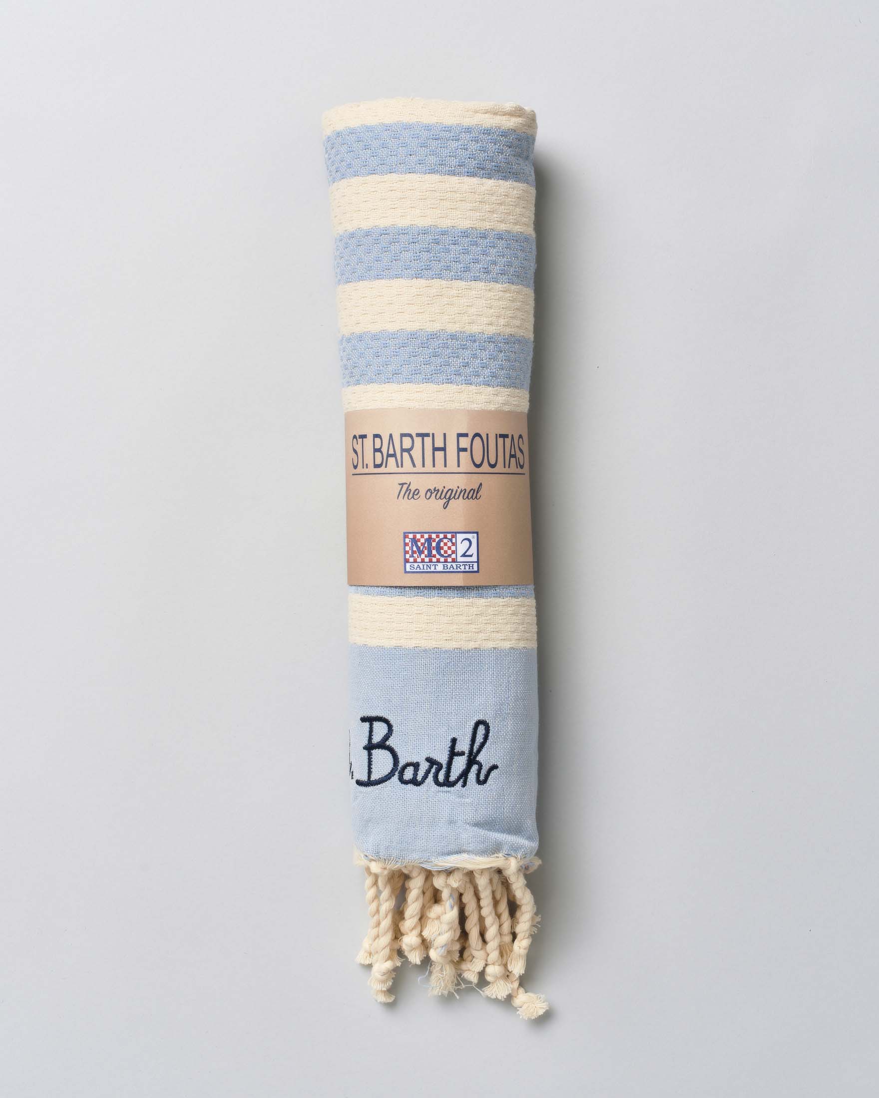 Telo mare azzurro in cotone a righe beige con frange al fondo e scritta logo ricamata