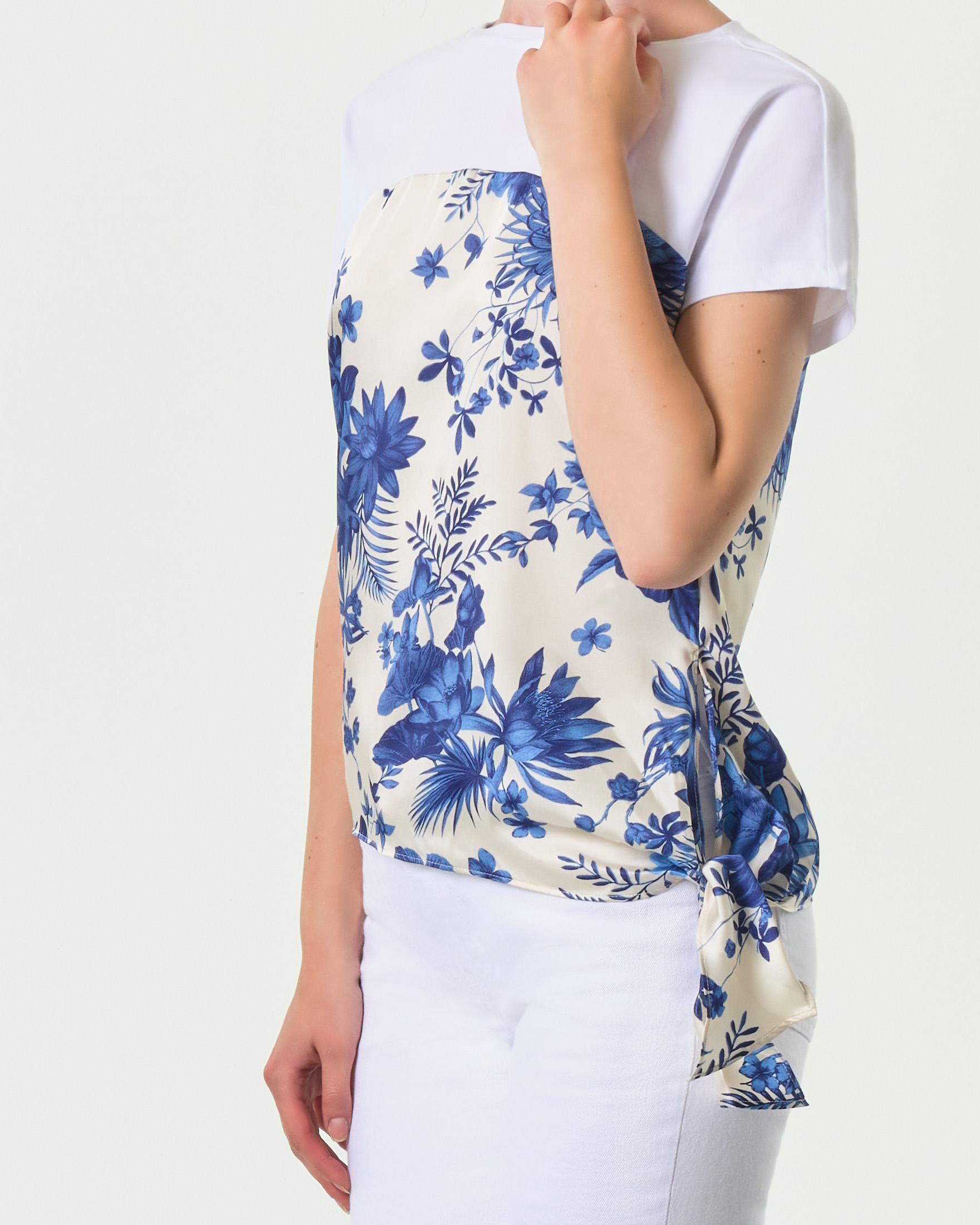 T-shirt bianca in cotone e in twill stampato a fantasia floreale blu con fiocco al fondo