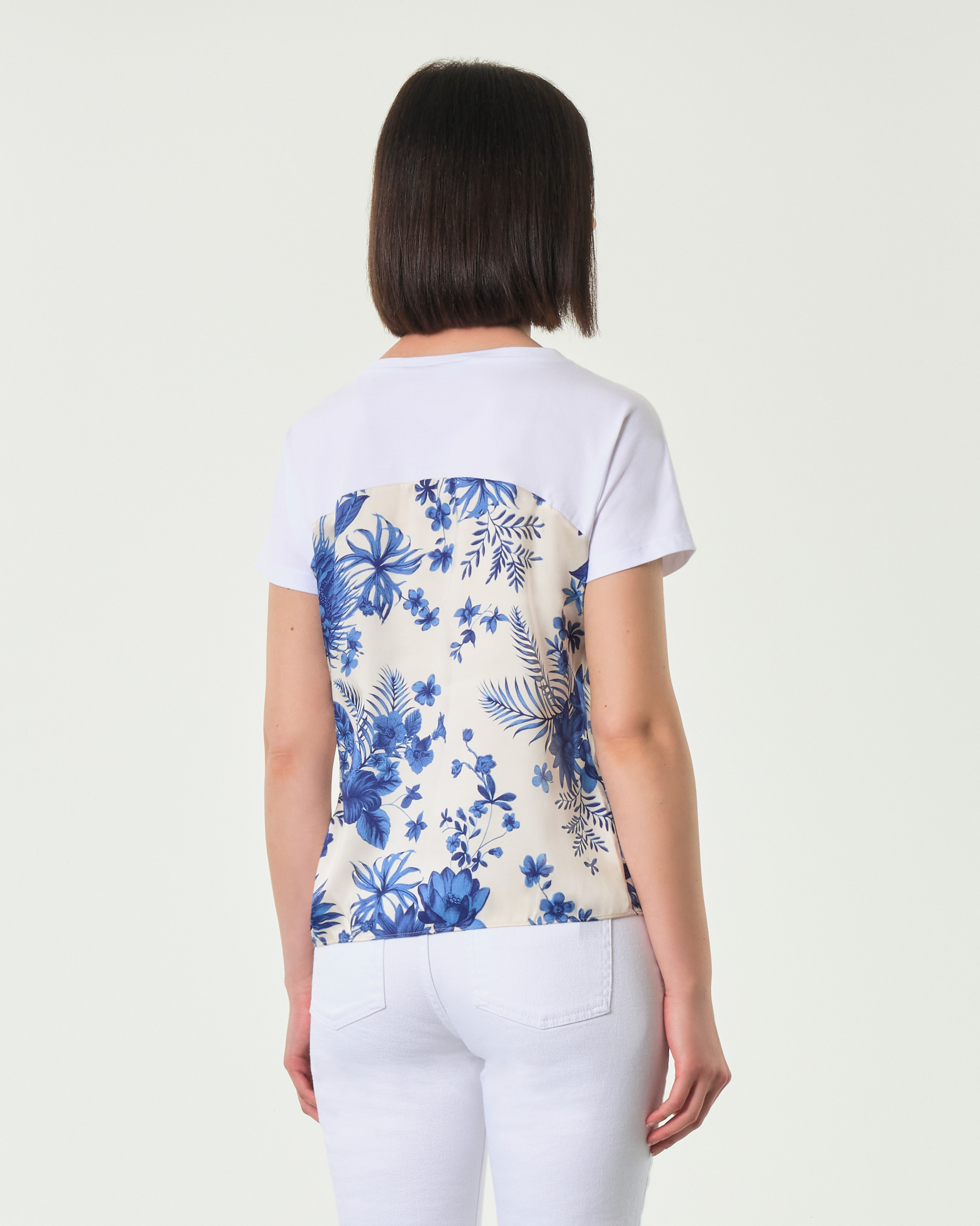 T-shirt bianca in cotone e in twill stampato a fantasia floreale blu con fiocco al fondo