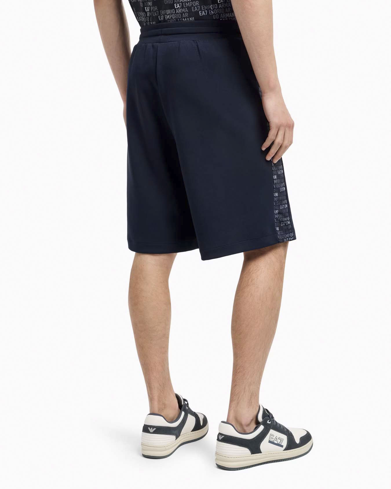 Bermuda EA7 blu in felpa con bande porta logo scritta ripetuta ai lati image