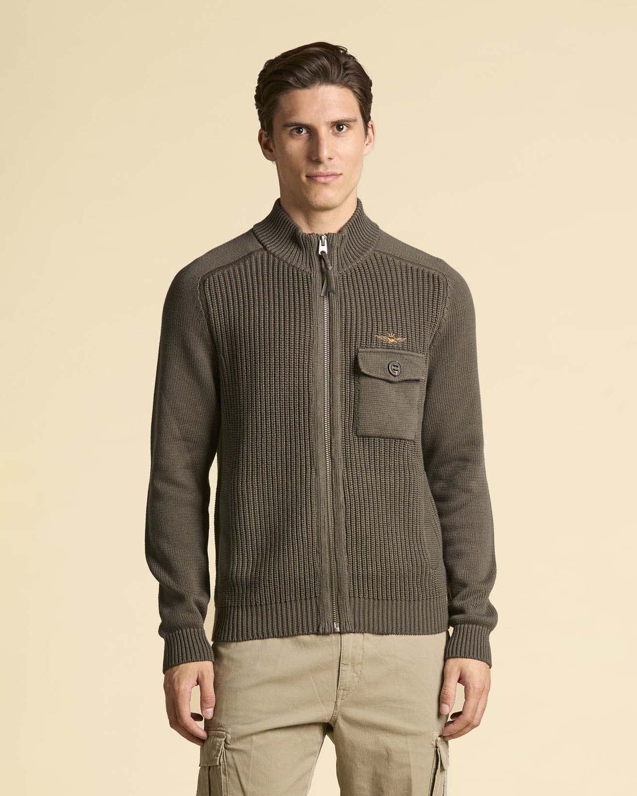 Maglia color fango a coste inglesi con collo alto chiusura zip e taschino al petto