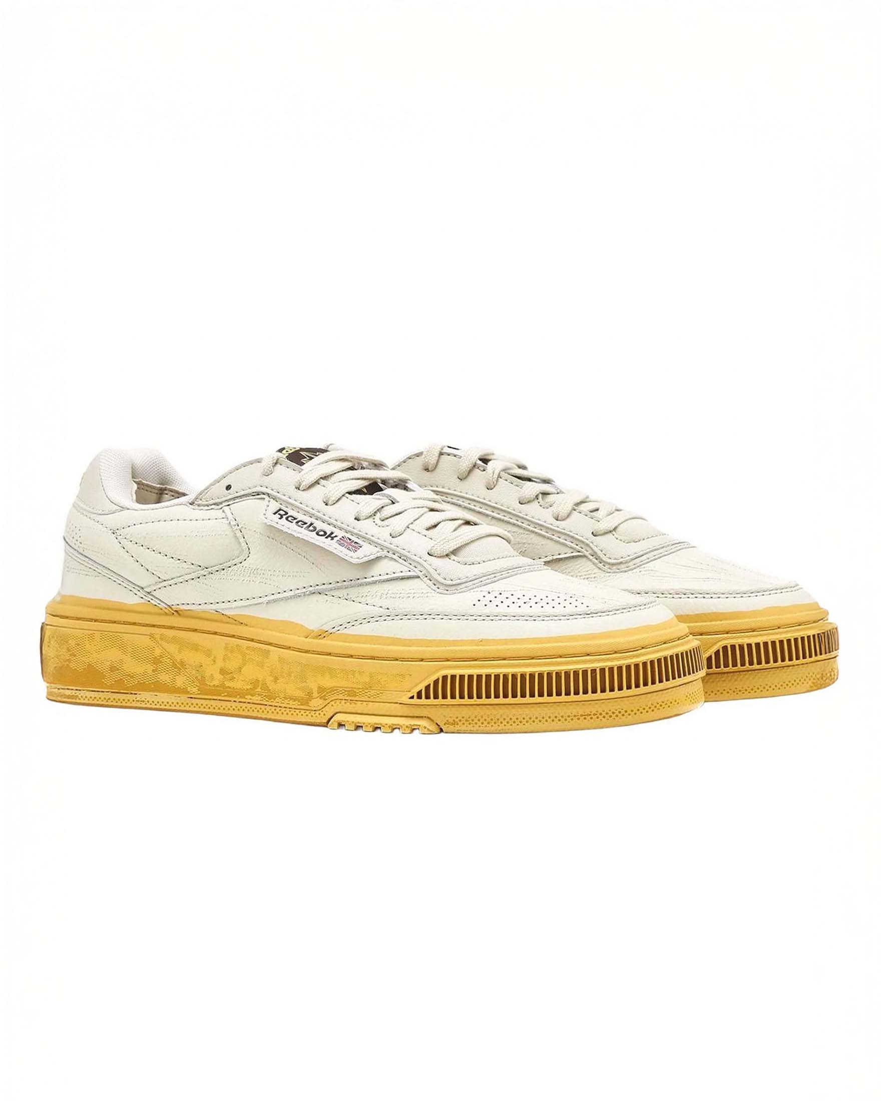 Sneakers Reebok Club C in pelle bianca graffiata con suola gialla effetto vintage image