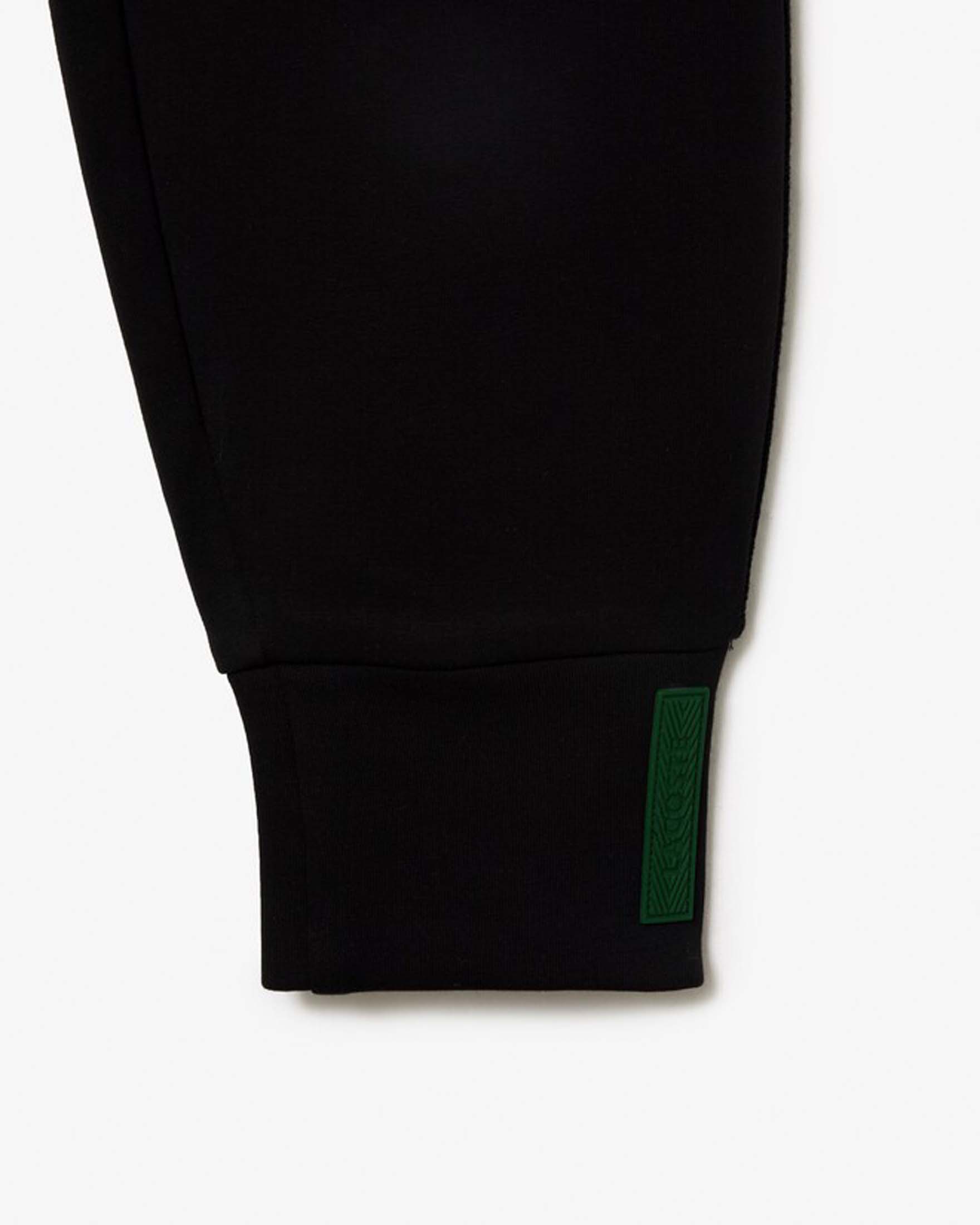 Pantaloni neri tapered Lacoste in misto cotone effetto neoprene con polsini al fondo