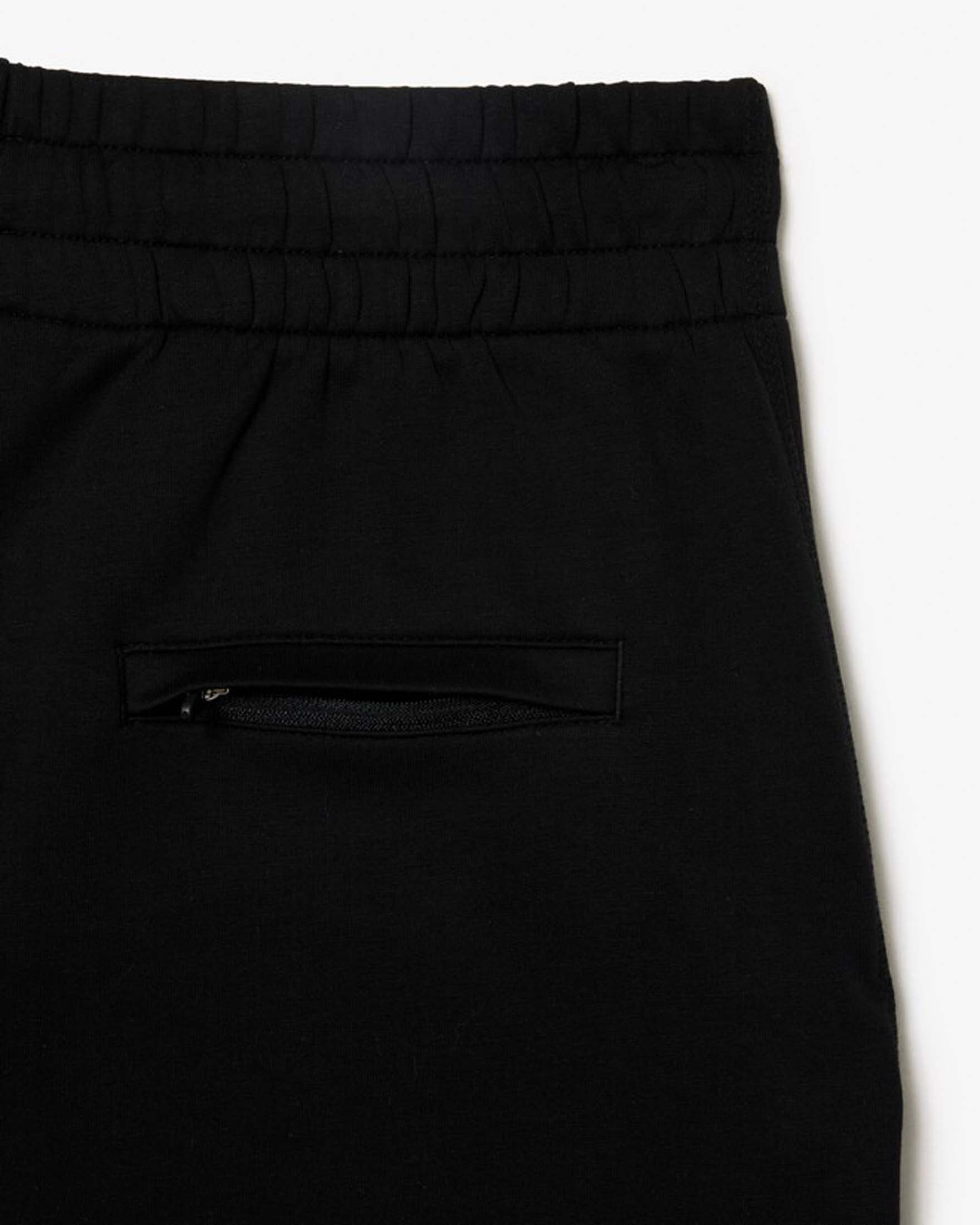 Pantaloni neri tapered Lacoste in misto cotone effetto neoprene con polsini al fondo