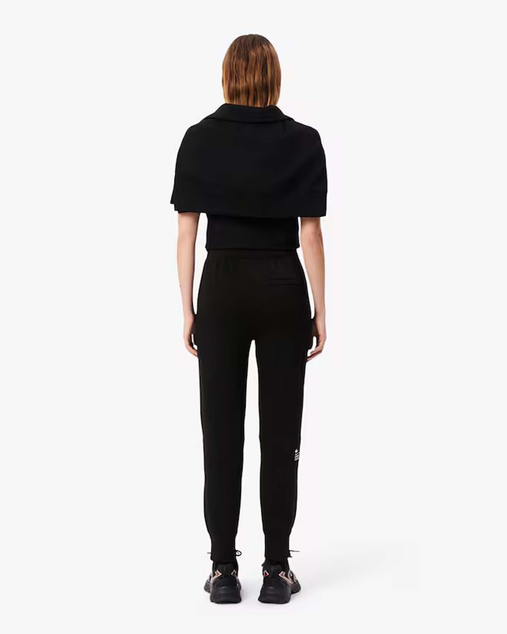 Pantaloni neri tapered Lacoste in misto cotone effetto neoprene con polsini al fondo