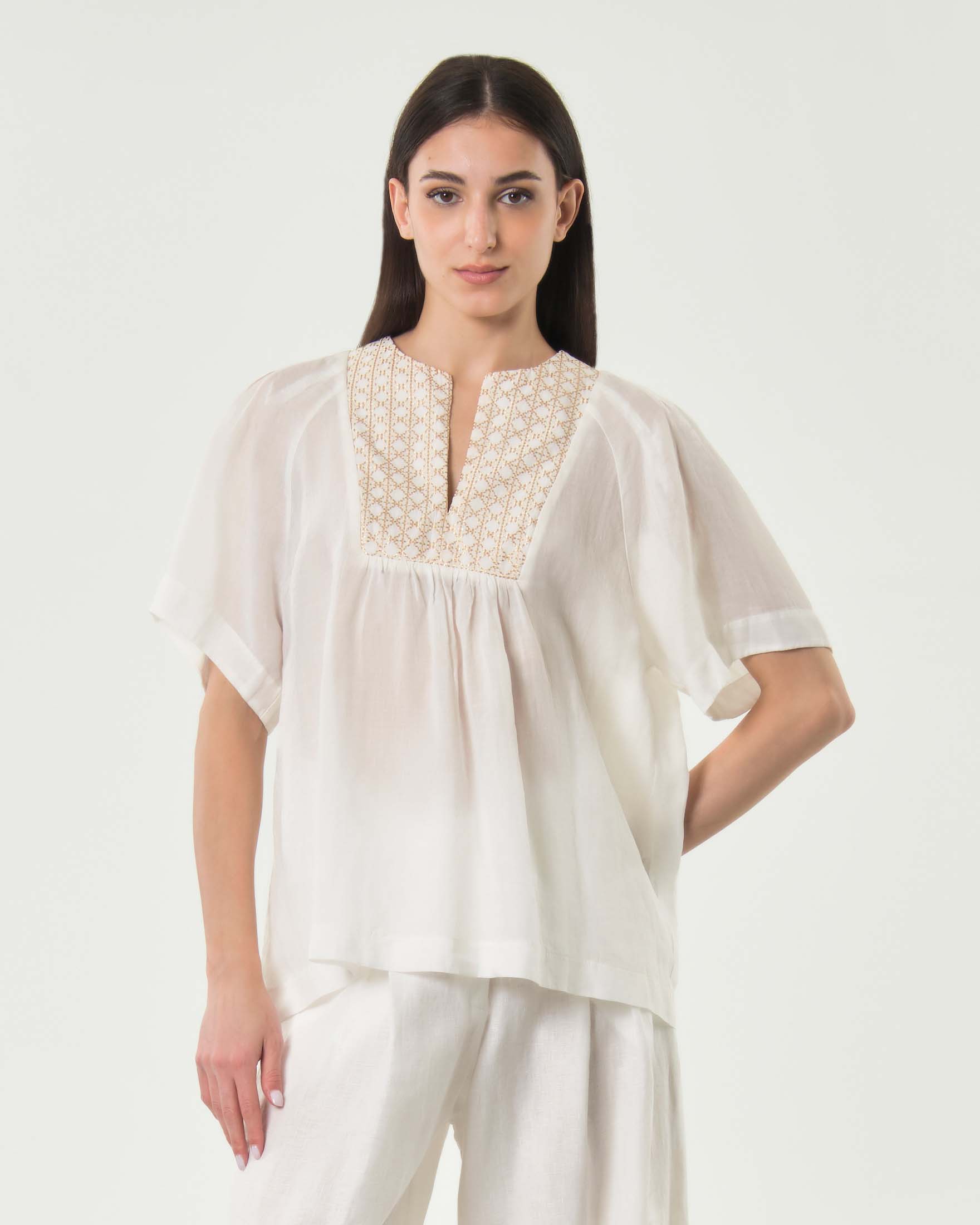 Blusa a mezze maniche bianca in ramié con ricamo dorato sul petto e arricciatura