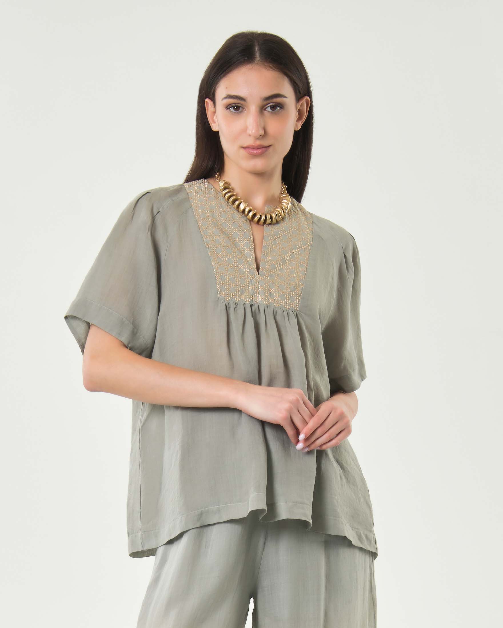 Blusa a mezze maniche grigia in ramié con ricamo dorato sul petto e arricciatura