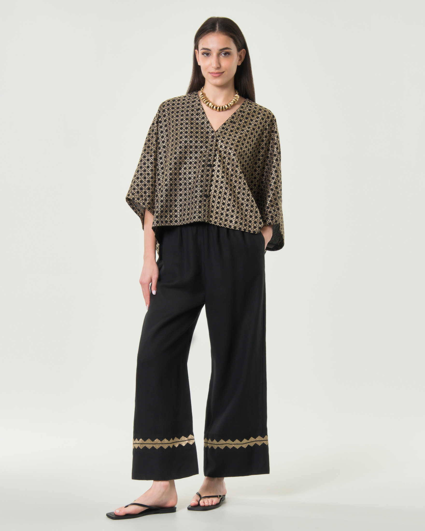 Pantaloni palazzo Greek Archaic Kori neri in lino con orlo ricamato in filo oro e vita elasticizzata
