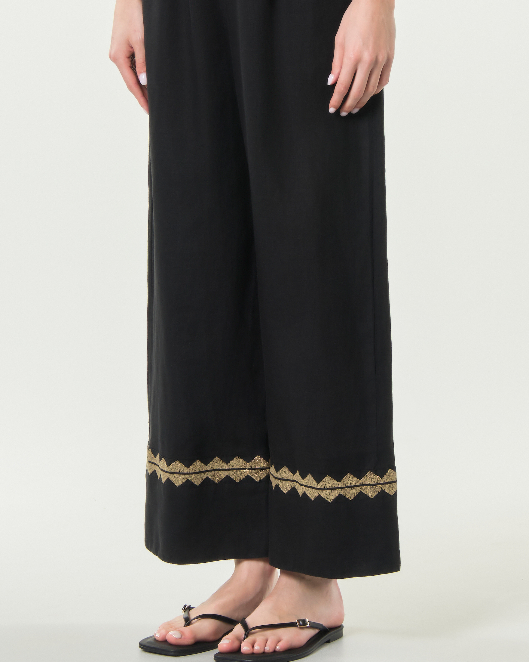 Pantaloni palazzo Greek Archaic Kori neri in lino con orlo ricamato in filo oro e vita elasticizzata image