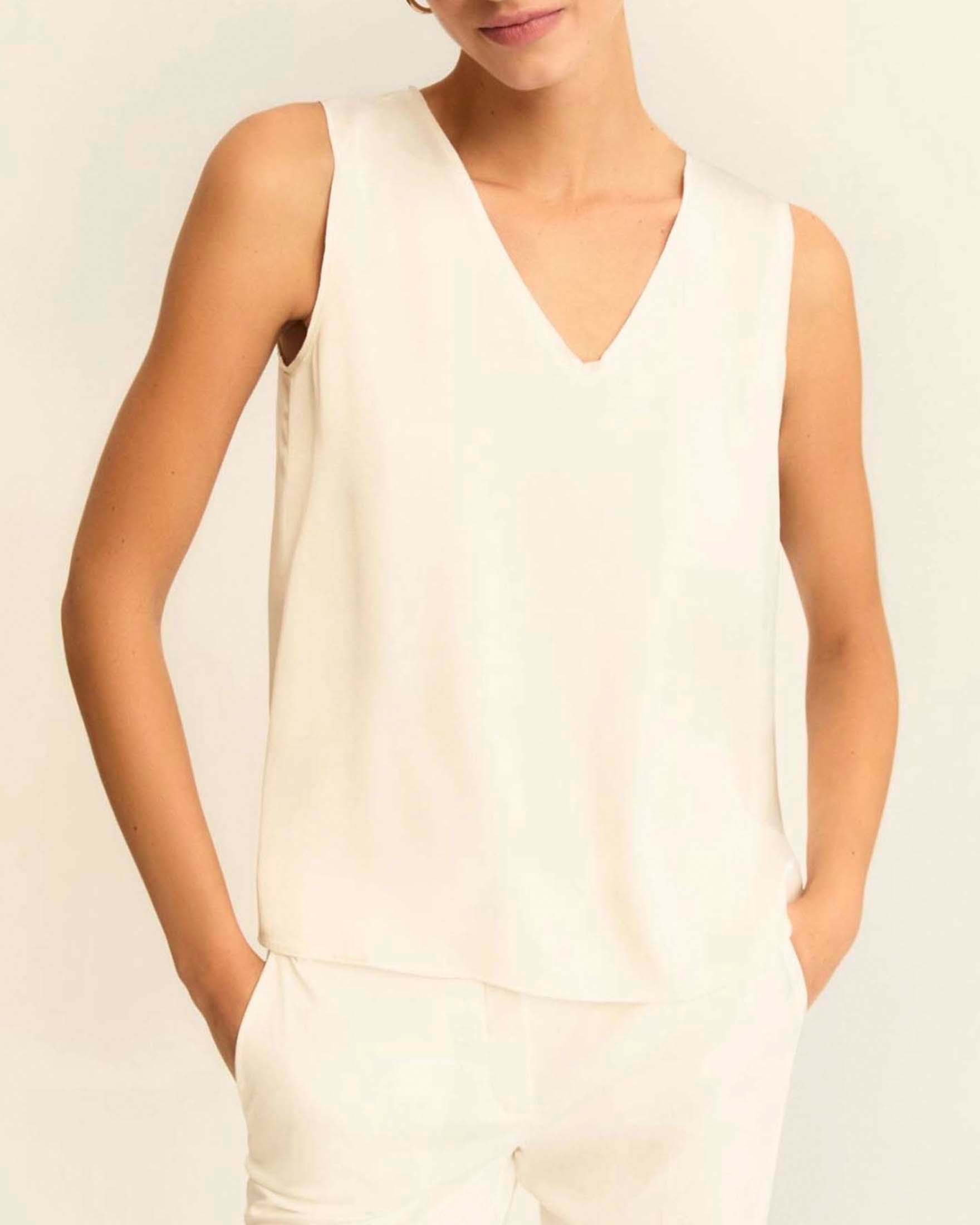 Top smanicato bianco in raso tecnico con scollo a V e dettagli in georgette