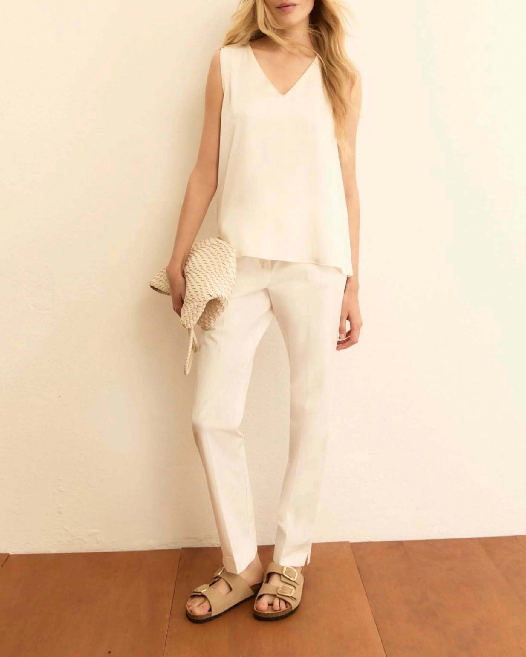 Pantaloni slim bianchi in gabardina stretch con piega stirata e spacco alla caviglia
