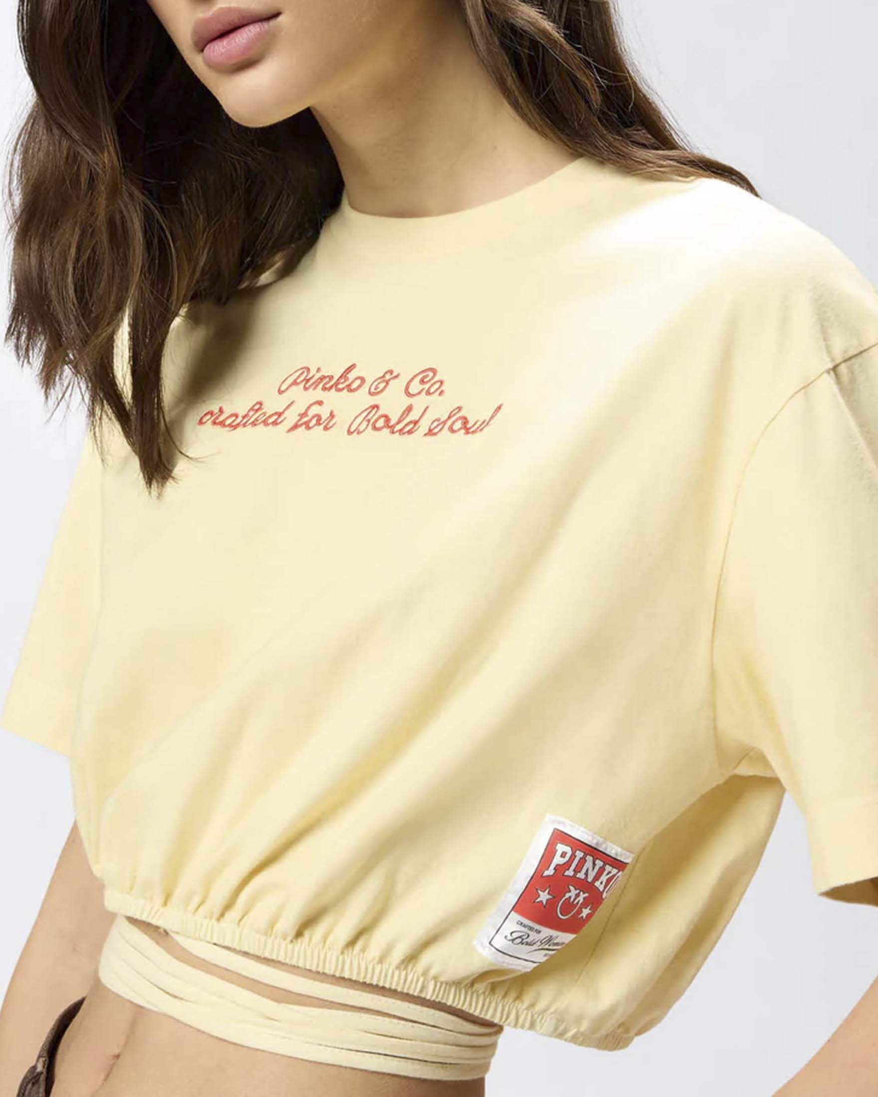 Crop top a mezza manica Pinko color burro in cotone con ricamo logo e stampa sul retro
