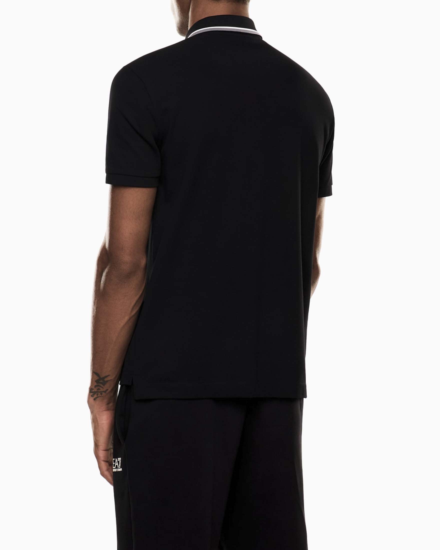 Polo EA7 nera in cotone stretch con logo stampato e bordini a contrasto image