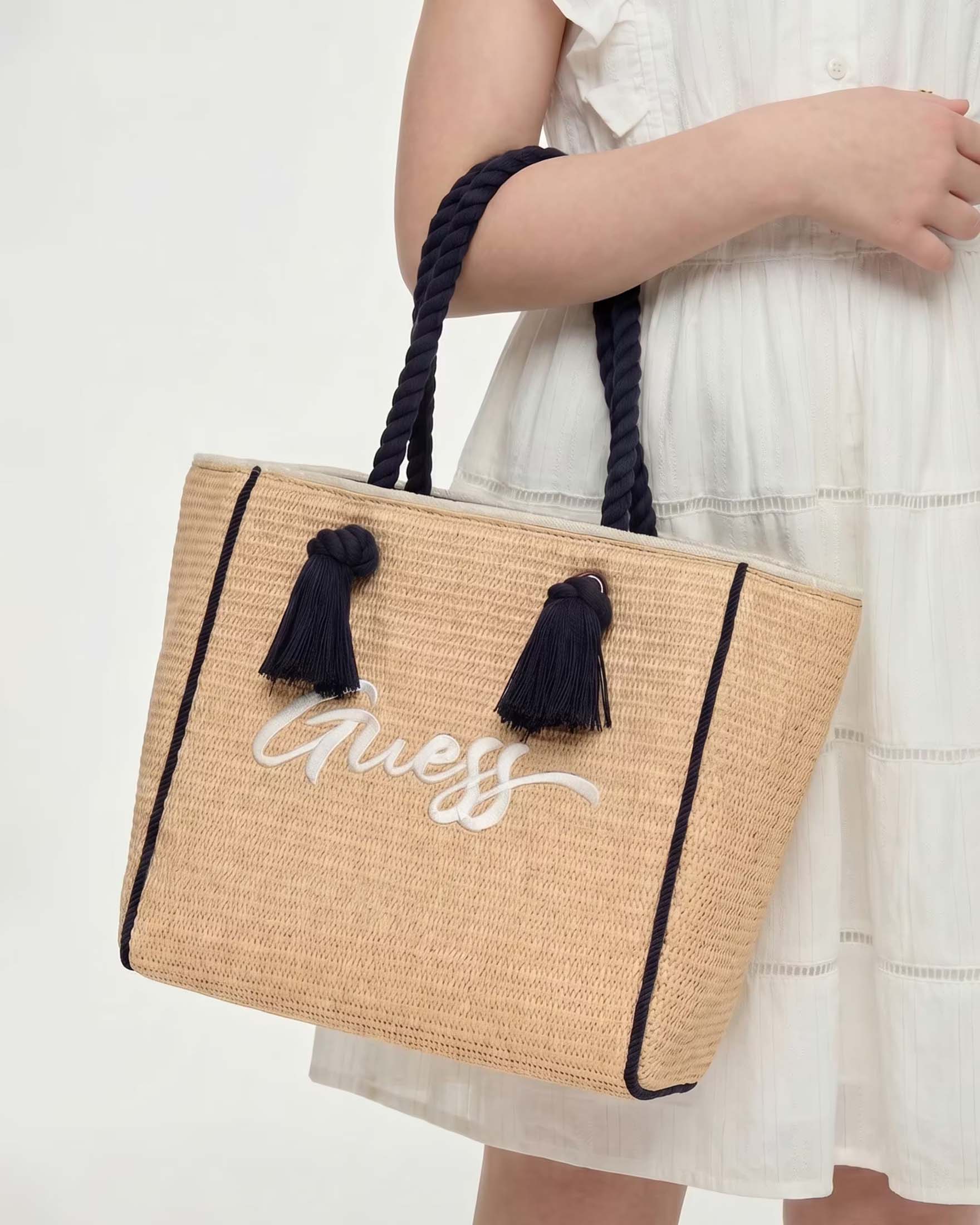 Borsa shopper Guess in rafia con manici neri e scritta logo bianca