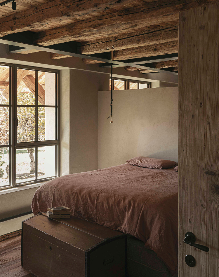 camera con rivestimenti in legno antico e travi a vista
