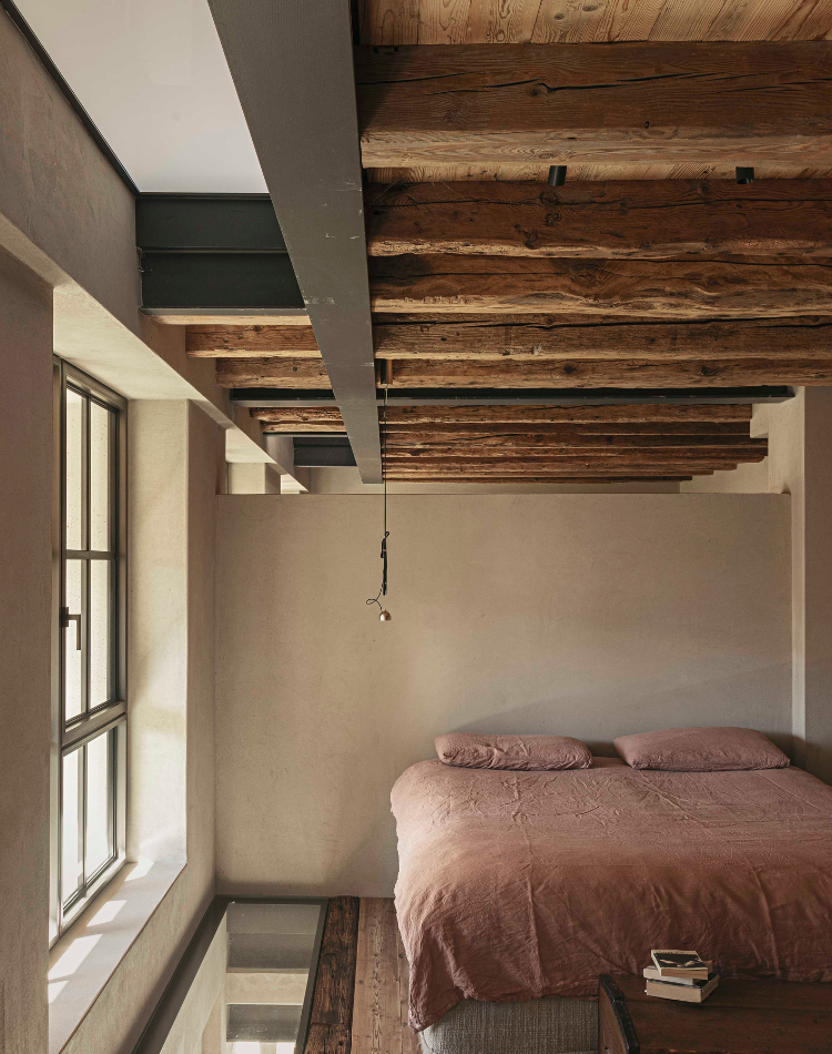 camera con travi a legno a vista e parquet antico