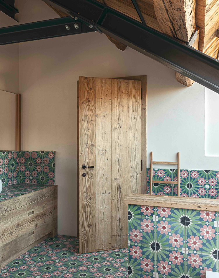 bagno con mobili in abete e pareti in piastrelle decorate