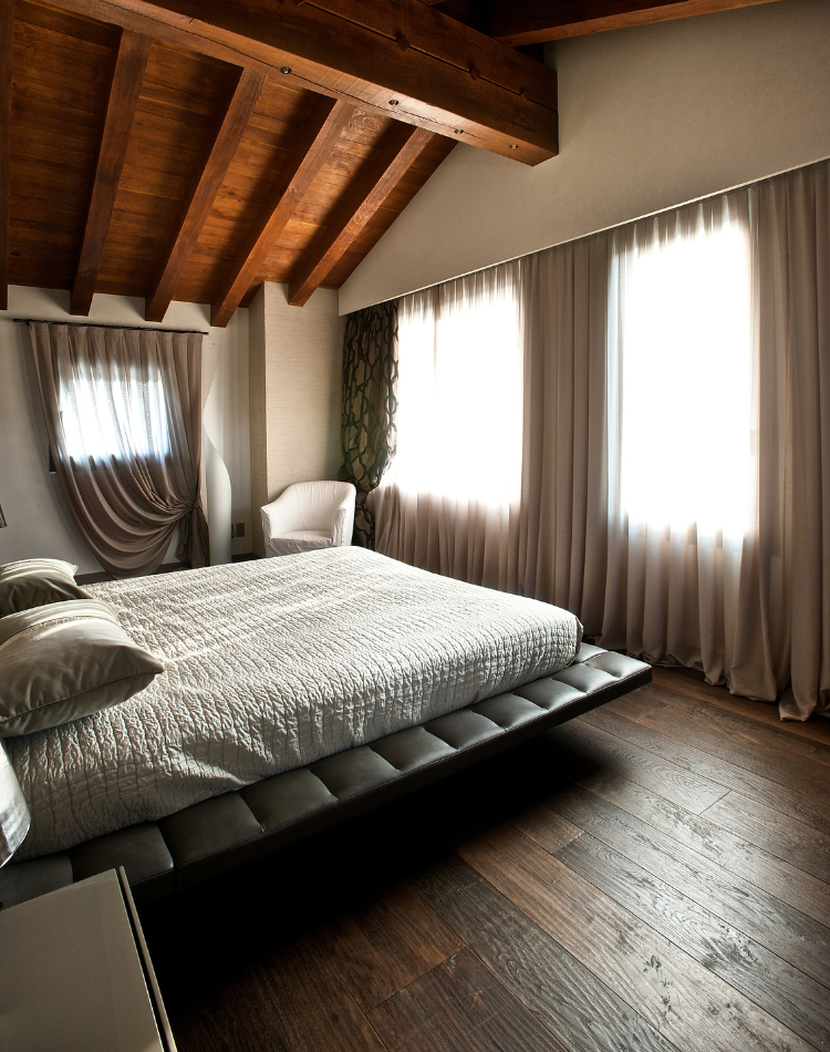 camera con parquet in legno di rovere e soffitto travi a vista