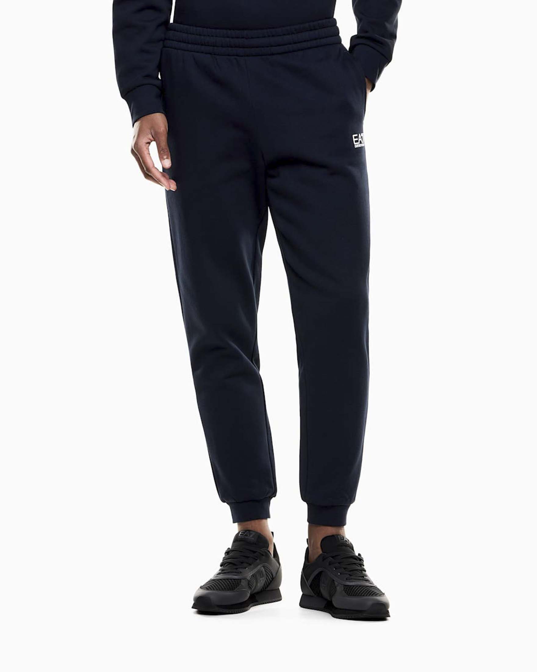 Pantaloni EA7 blu in felpa di cotone con logo bianco gommato sul fianco destro
