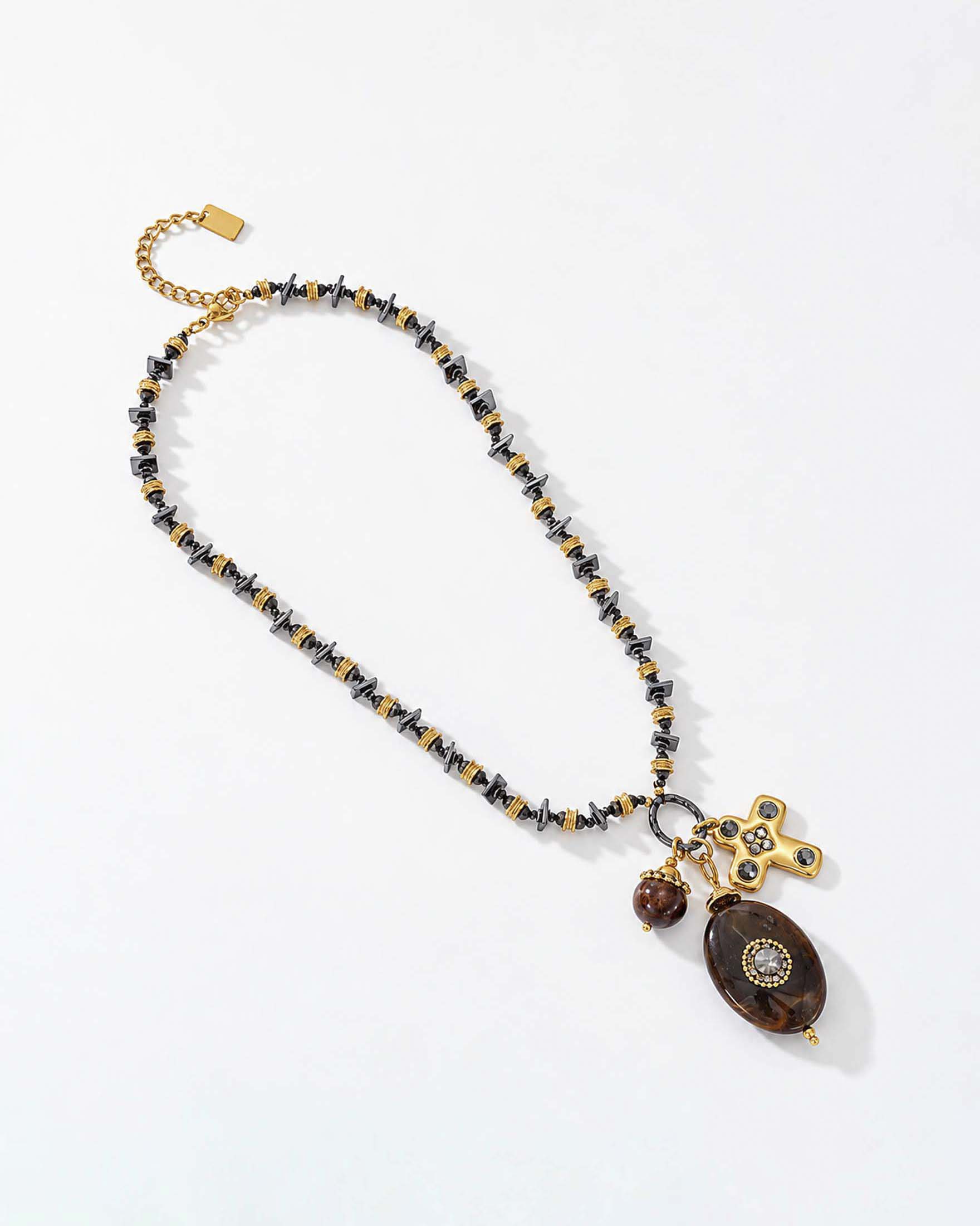 Collana Somini dorata con perline scure e pendenti decorativi con sfumature effetto osso